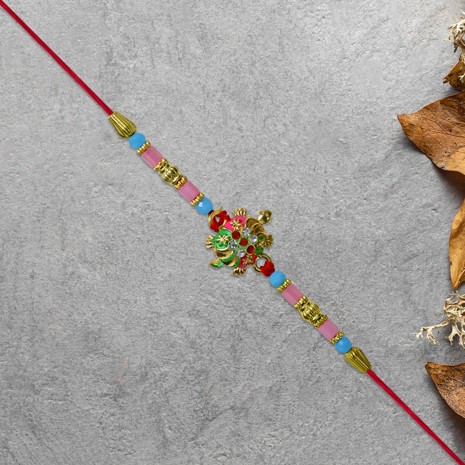 Turtle Design Rakhi With Floral Accents And Beads Turtle Design Rakhi With Floral Accents And Beads